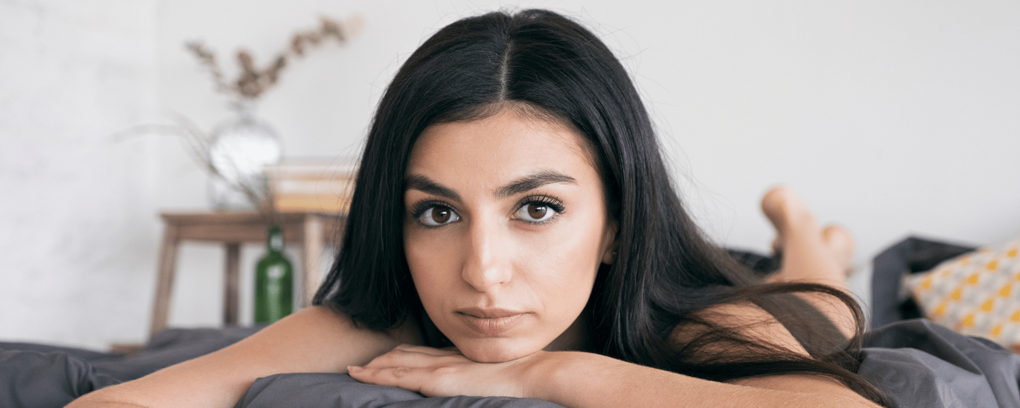 femme-brune-couche-sur-un-lit