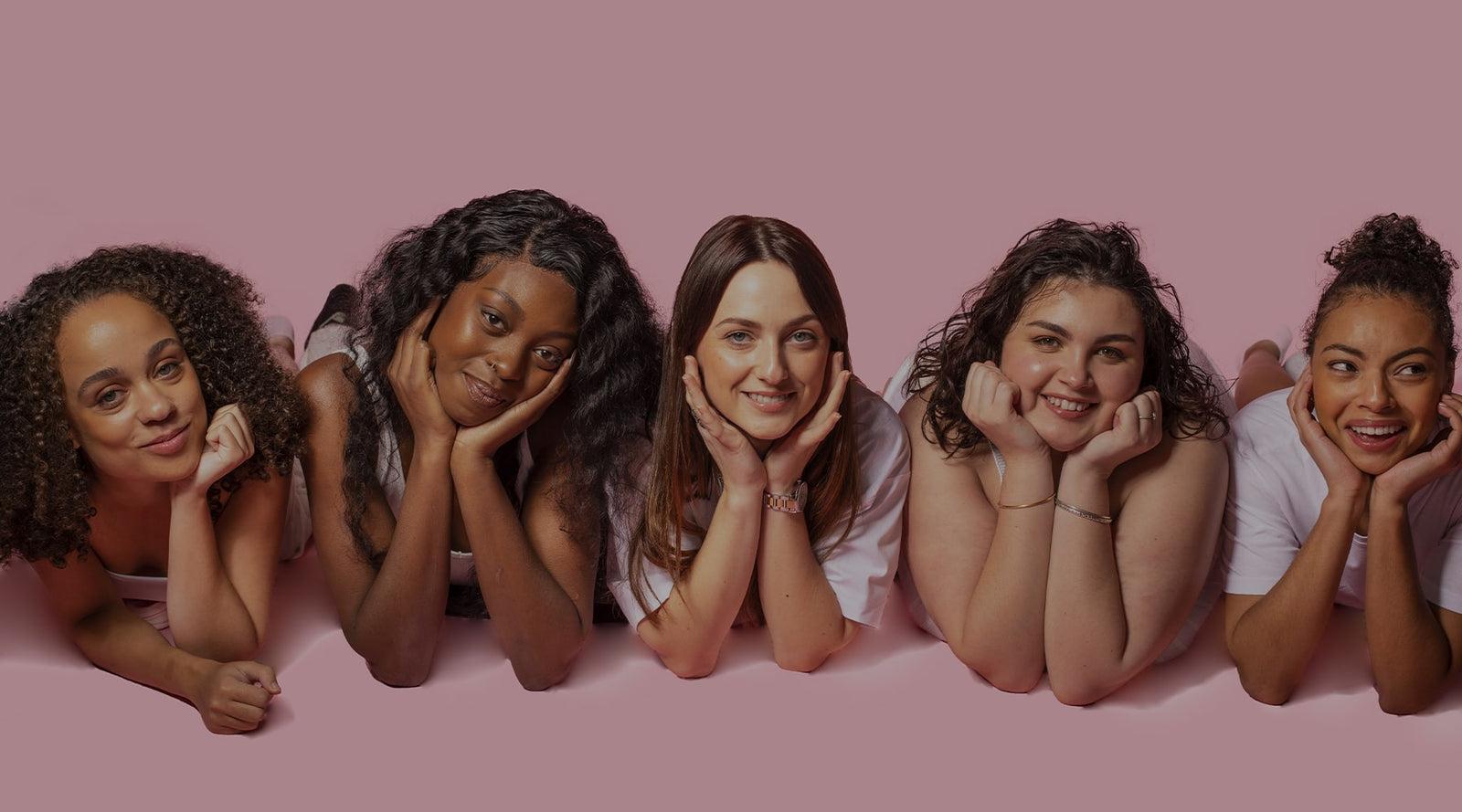 groupe-de-femmes-souriantes-en-tenue-blanche-allongées-sur-le-sol